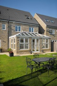 Cream upvc orangery installation with brick structure