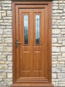 uPVC entrance door in golden oak with decorative glass panels and silver hardware