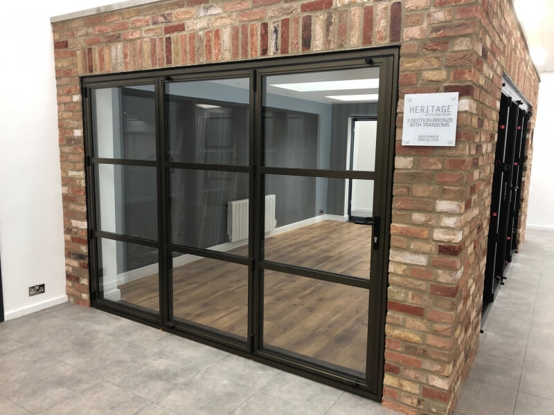 Alitherm brown heritage bi folding door on a stone wall showroom
